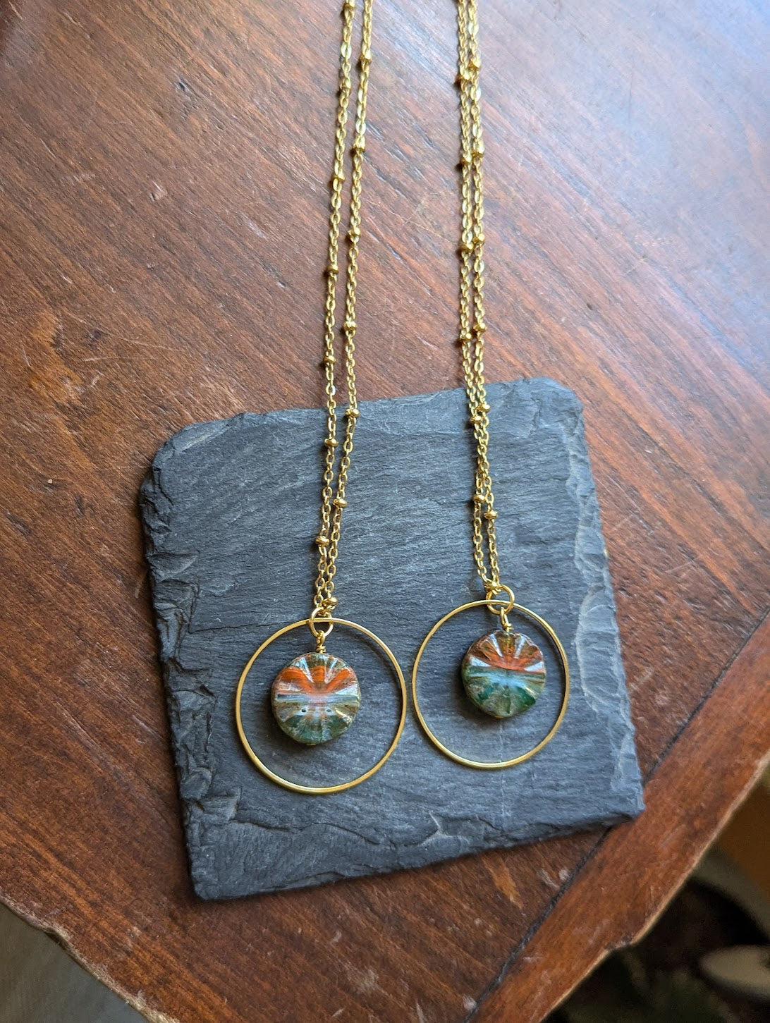Collar de aro dorado con vidrio grabado rojo y verde
