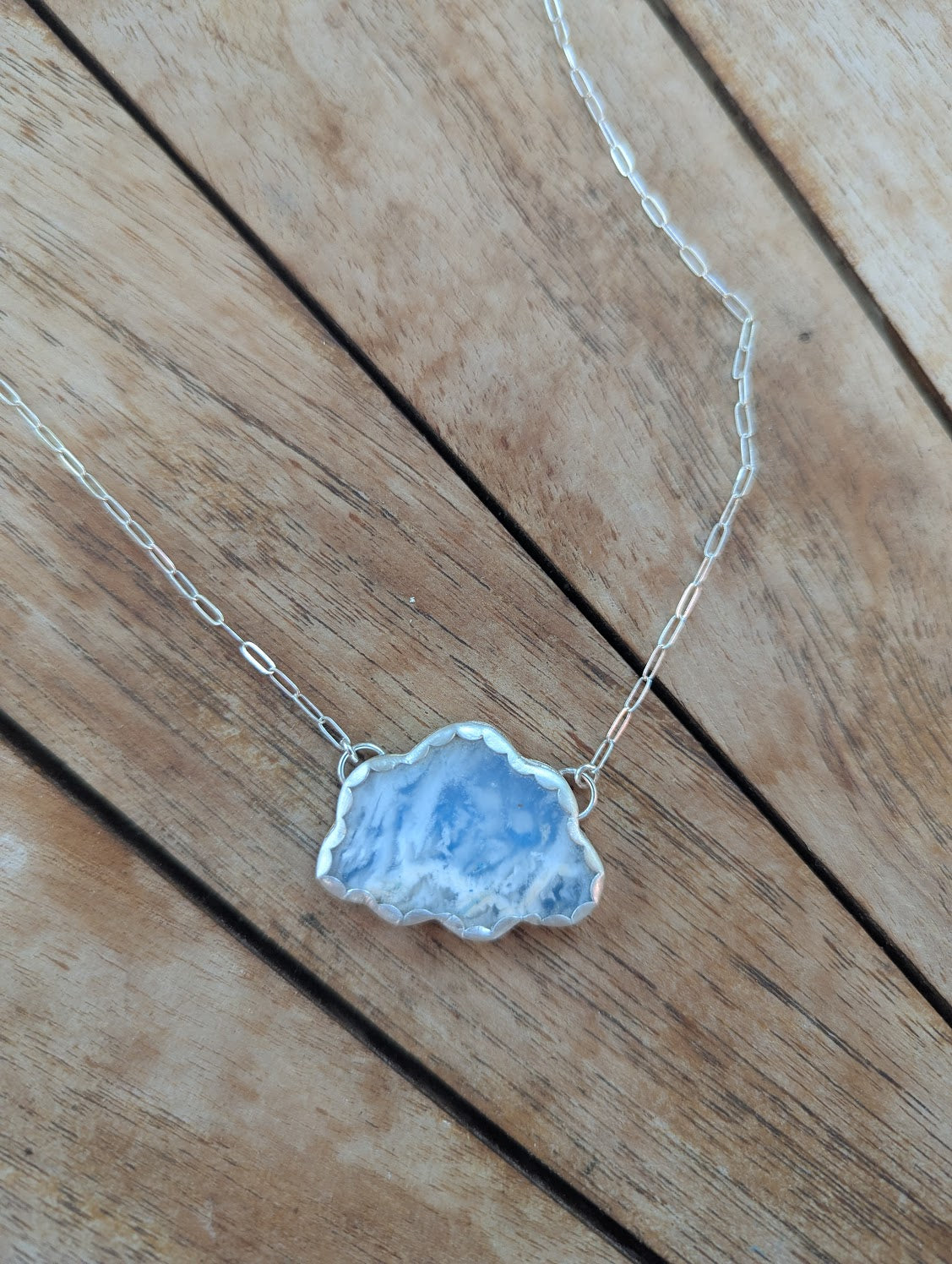 Collar de metal mixto con nubes de cielo azul