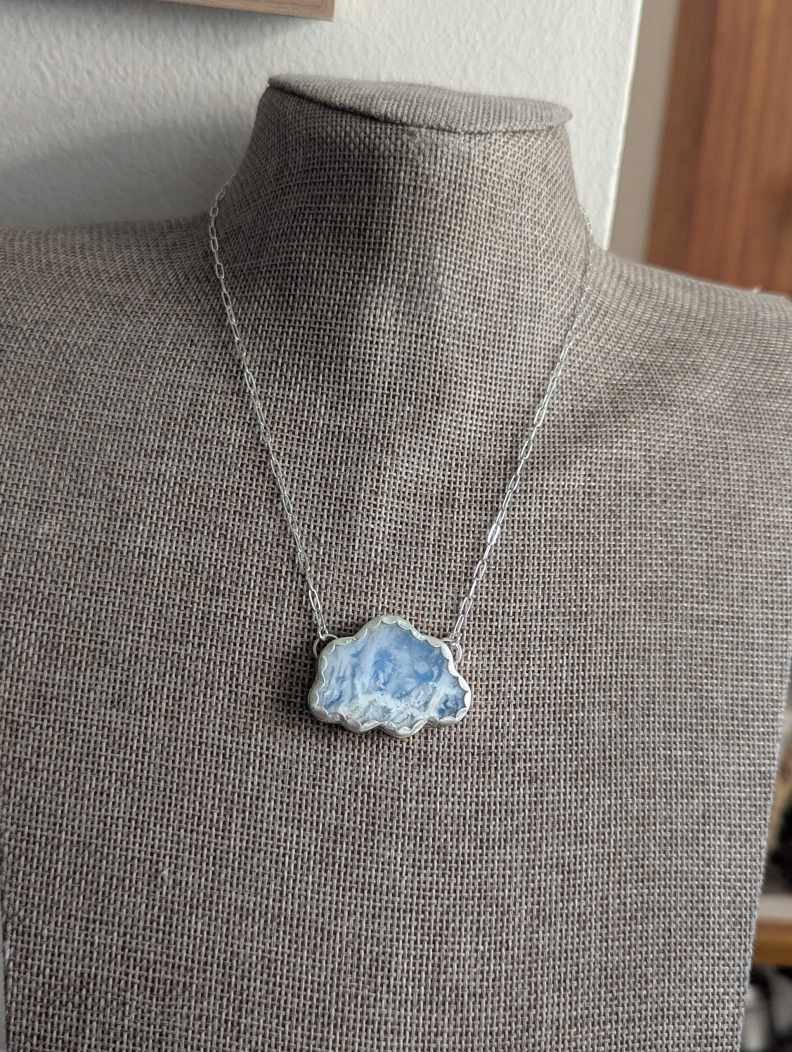Collar de metal mixto con nubes de cielo azul