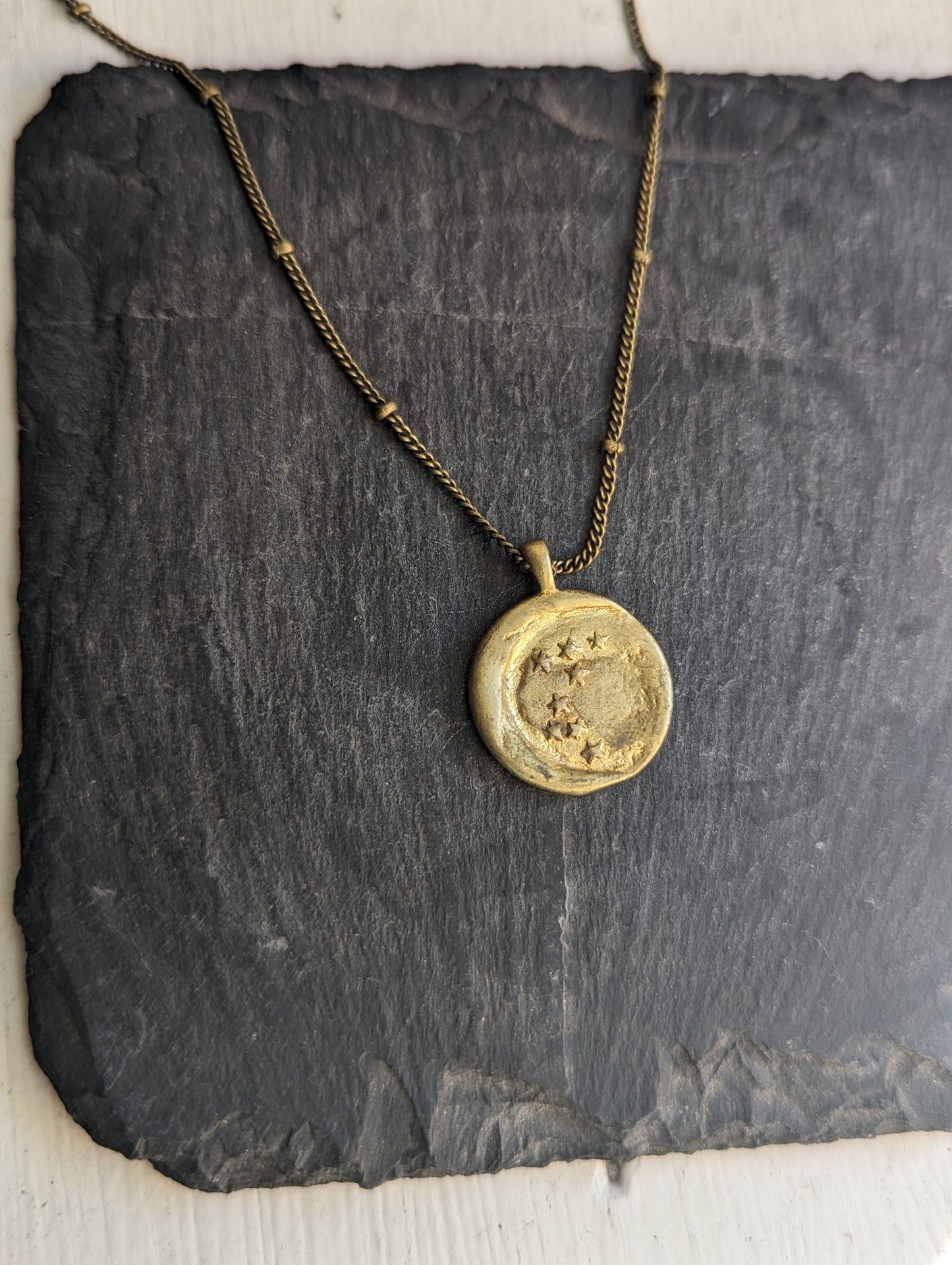 Talismán de latón con luna creciente y estrellas